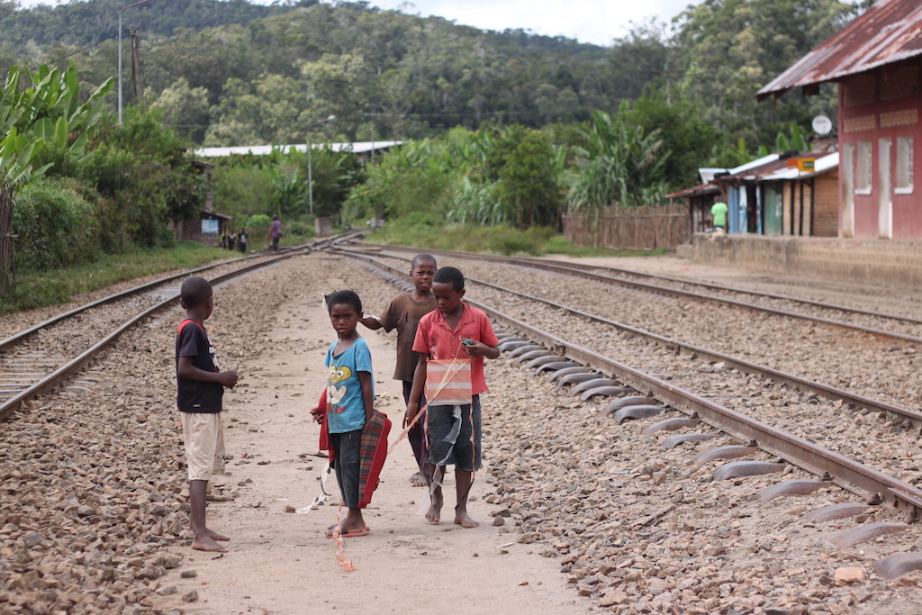 Children playing with kites at the train station